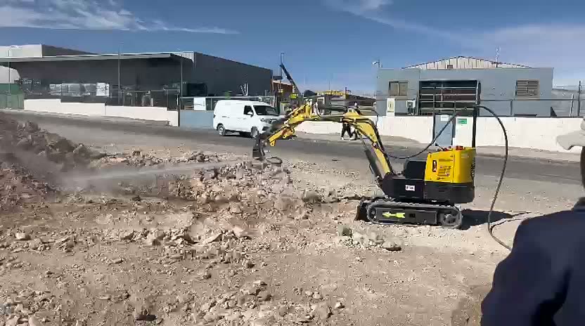 Miniexcavadora operada a distancia lanzando un chorro de agua a presión en una prueba real en terreno